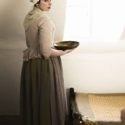 working woman getting dressed in the 18th century
